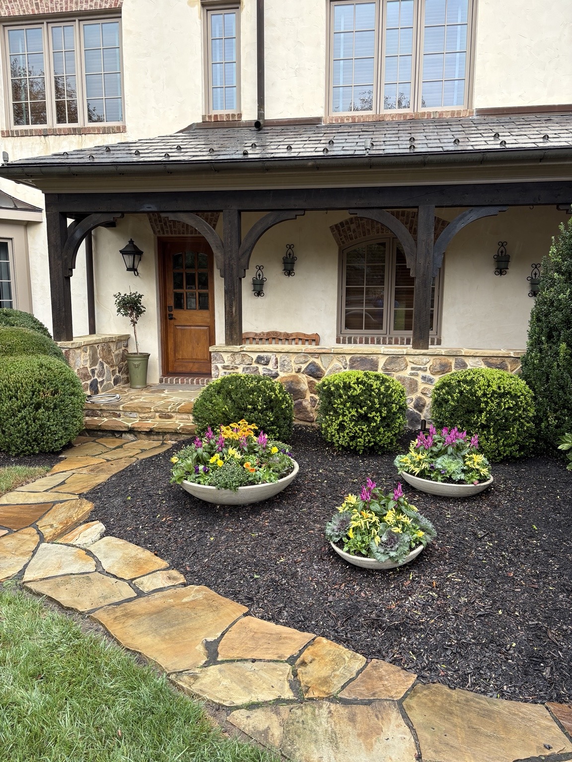 Three low seasonal planters outside a home
