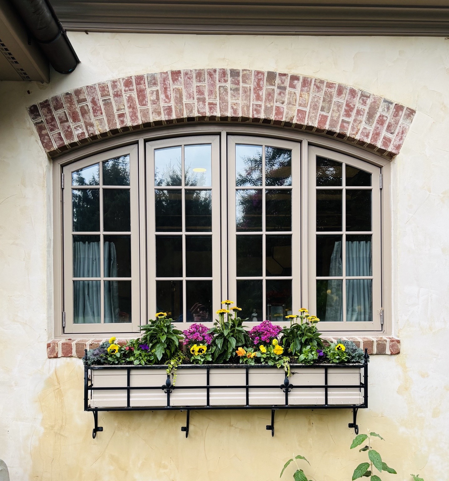 Seasonal window box beneath a brick arch window