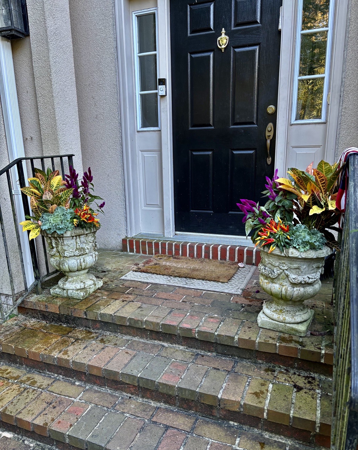 Matching seasonal planters welcoming visitors at a black front door
