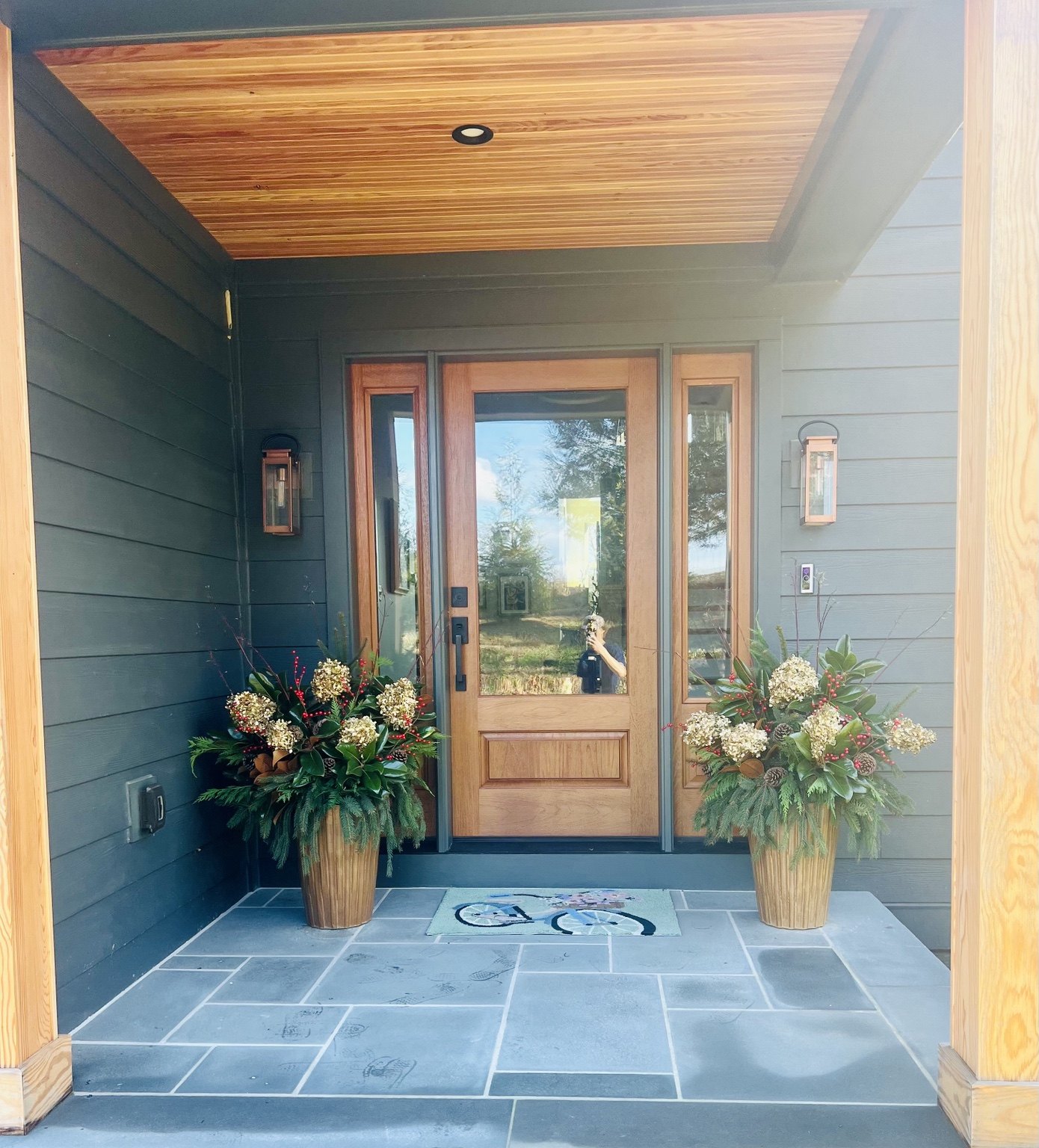 Pair of custom holiday planters at a welcoming front door