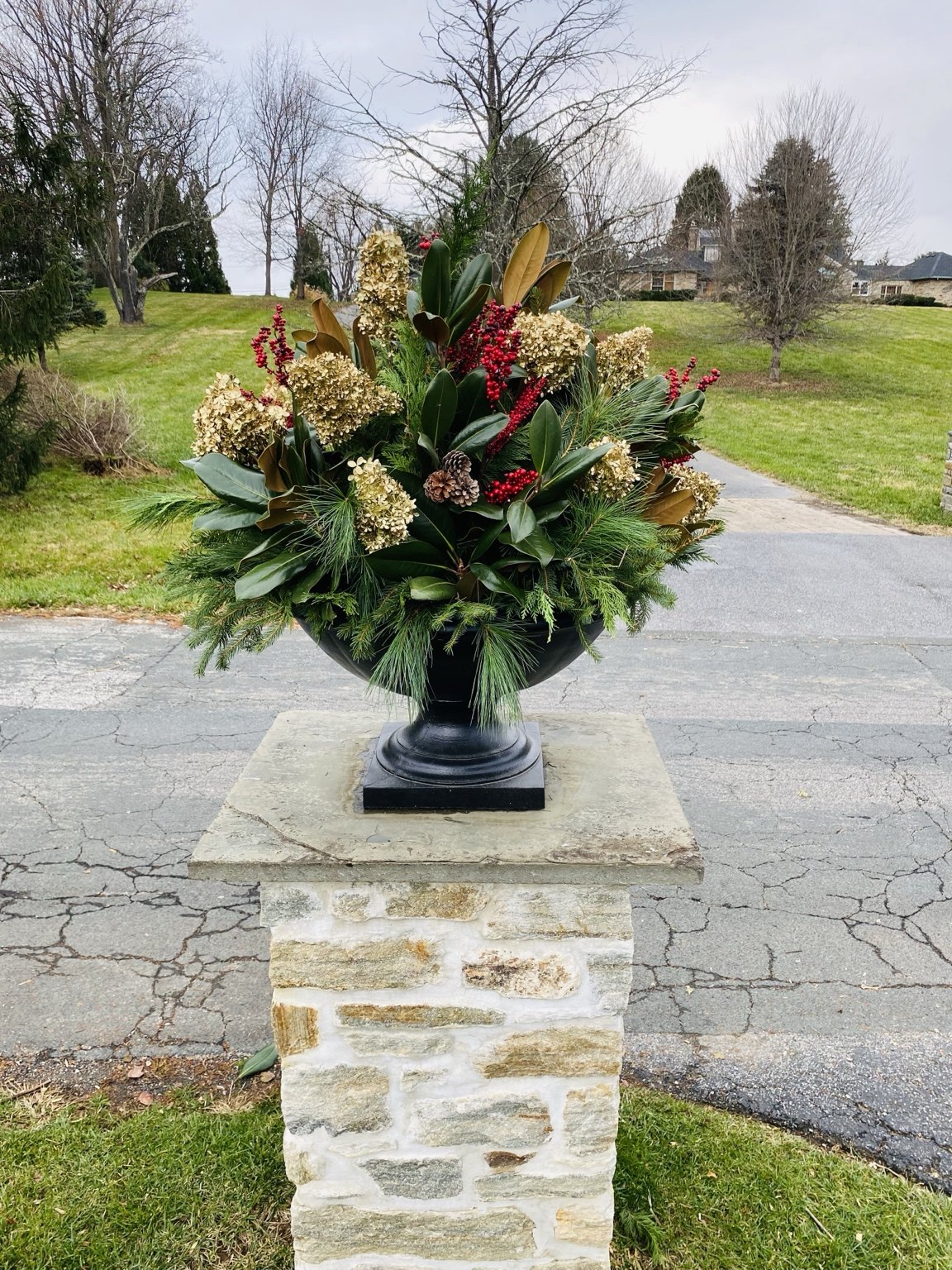 Statement holiday urn displayed on a stone pedestal