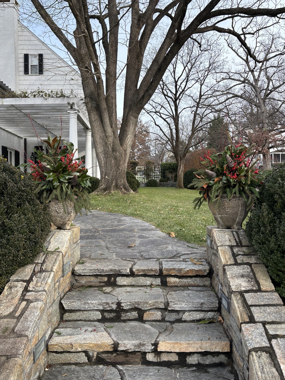 Matching holiday planters welcoming visitors along a stone walkway