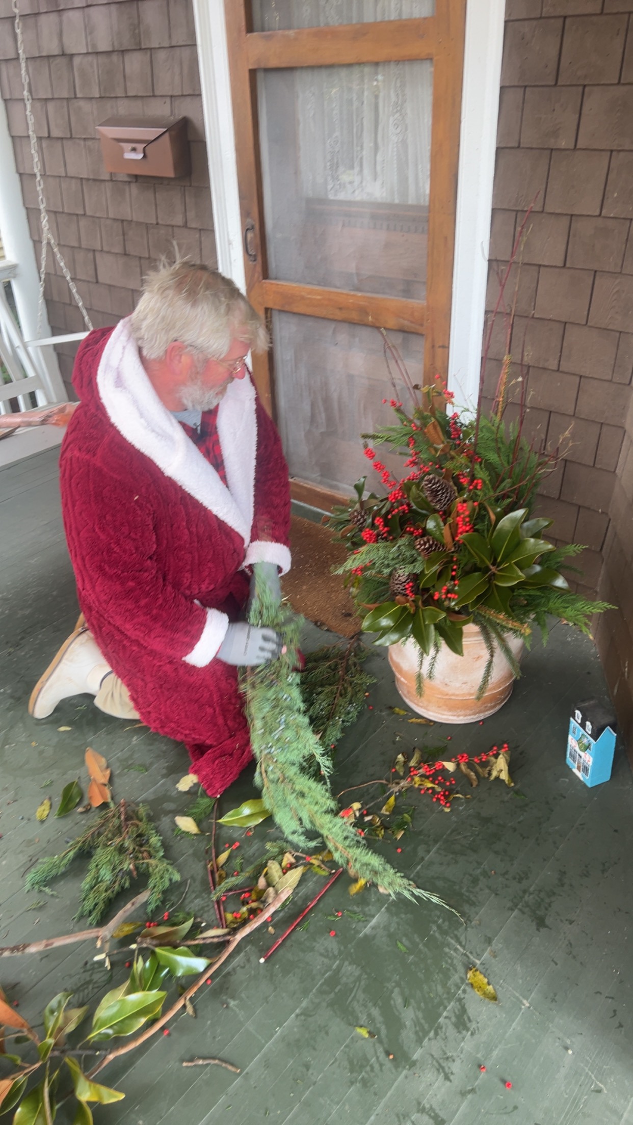 Santa decoration beside a holiday planter at a front entry
