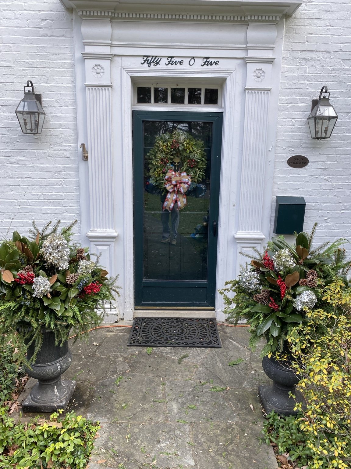 A pair of holiday planters flanking a front door