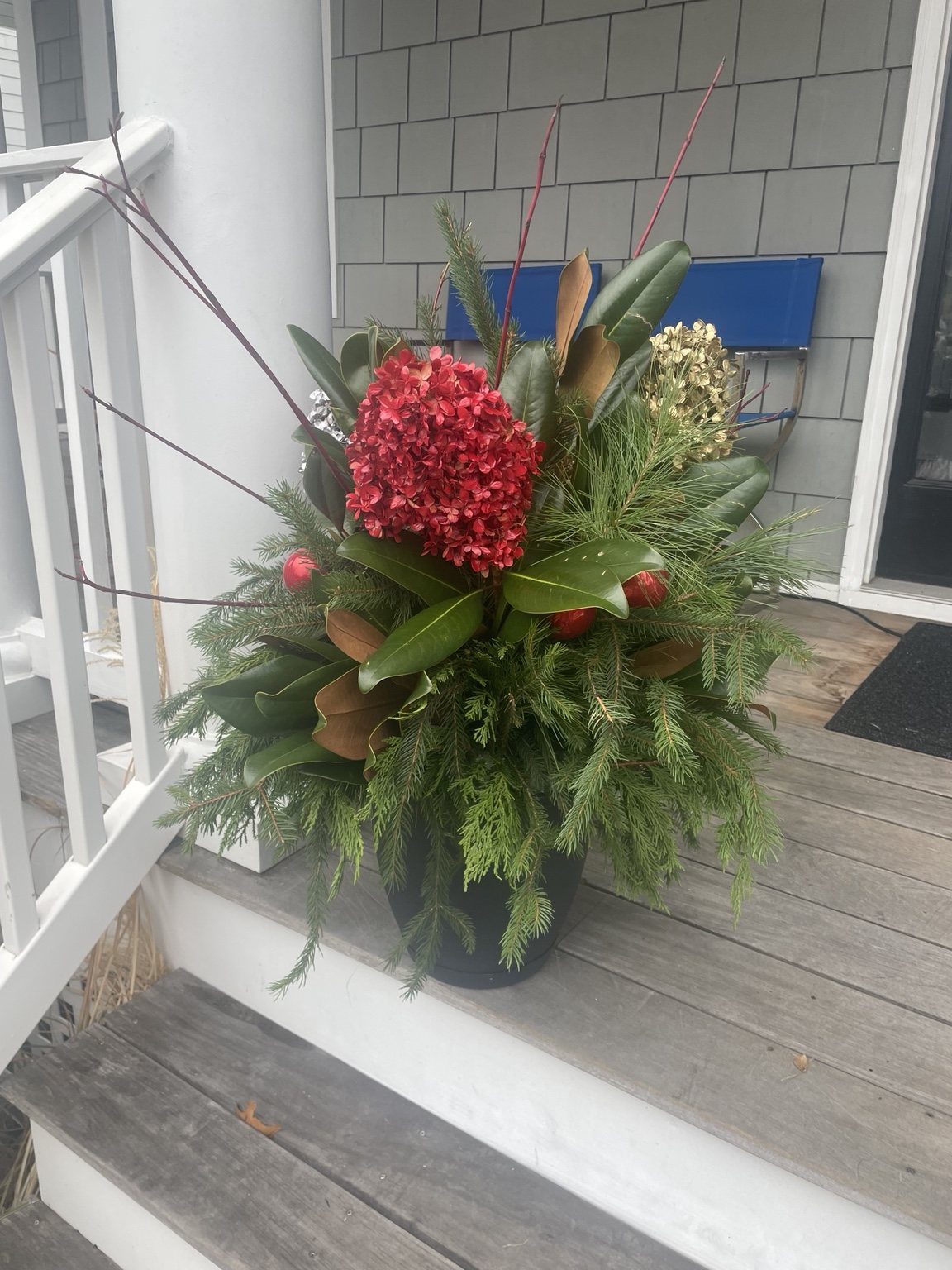 Holiday planter beside a porch railing