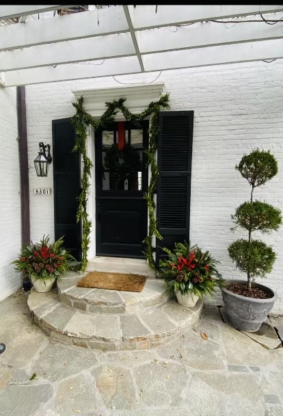 Holiday planters and wreath creating a festive entry