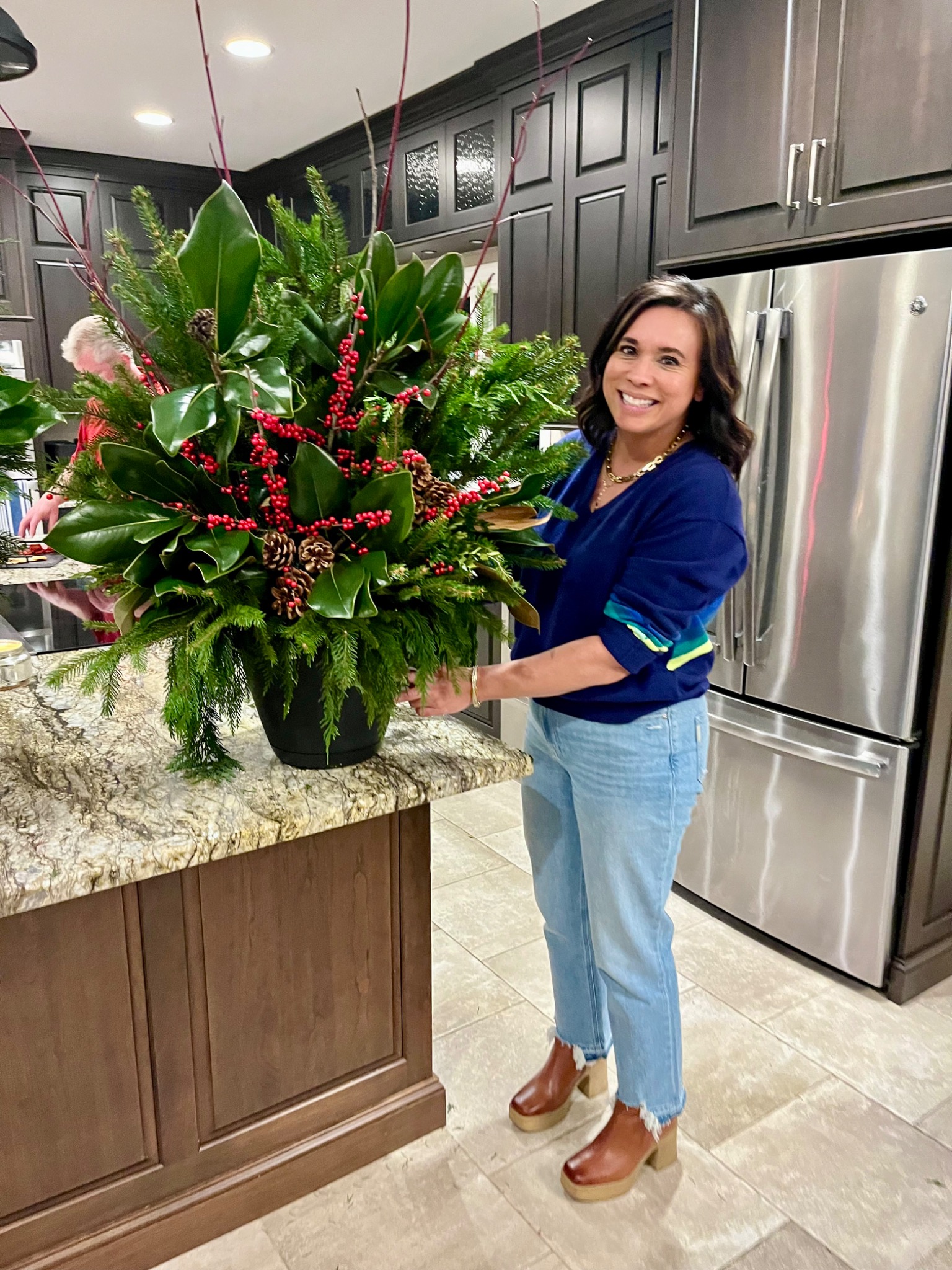 Guest working beside a full magnolia and evergreen arrangement