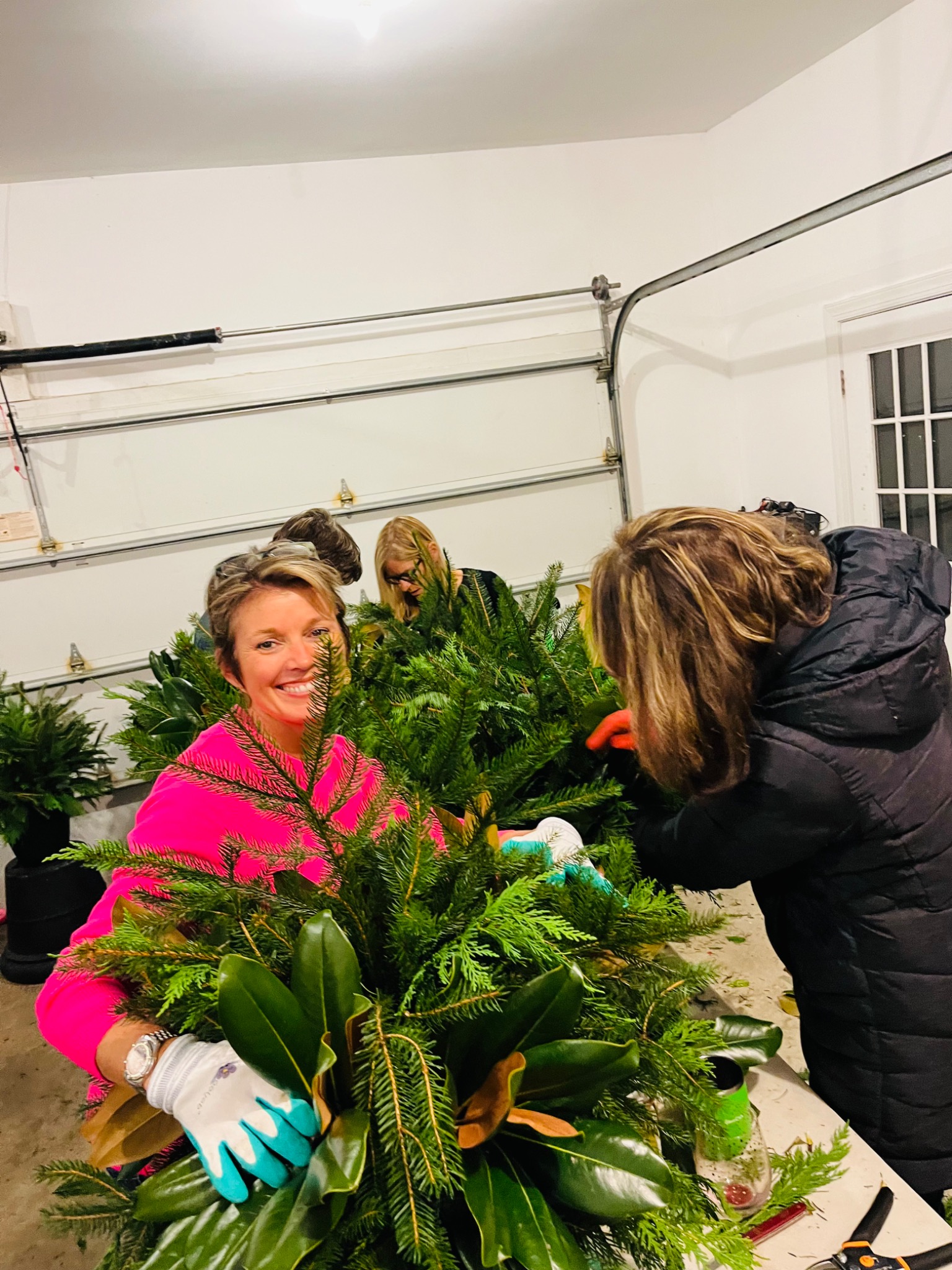Guests adding evergreen to a holiday planter