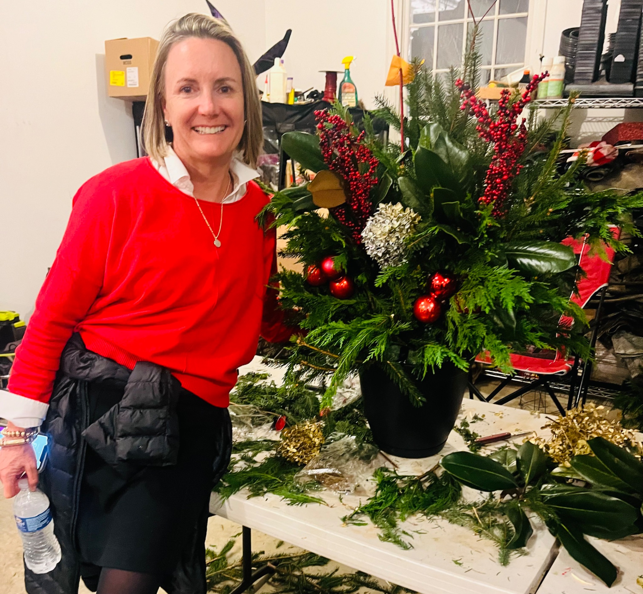 Guest beside a red and gold holiday planter