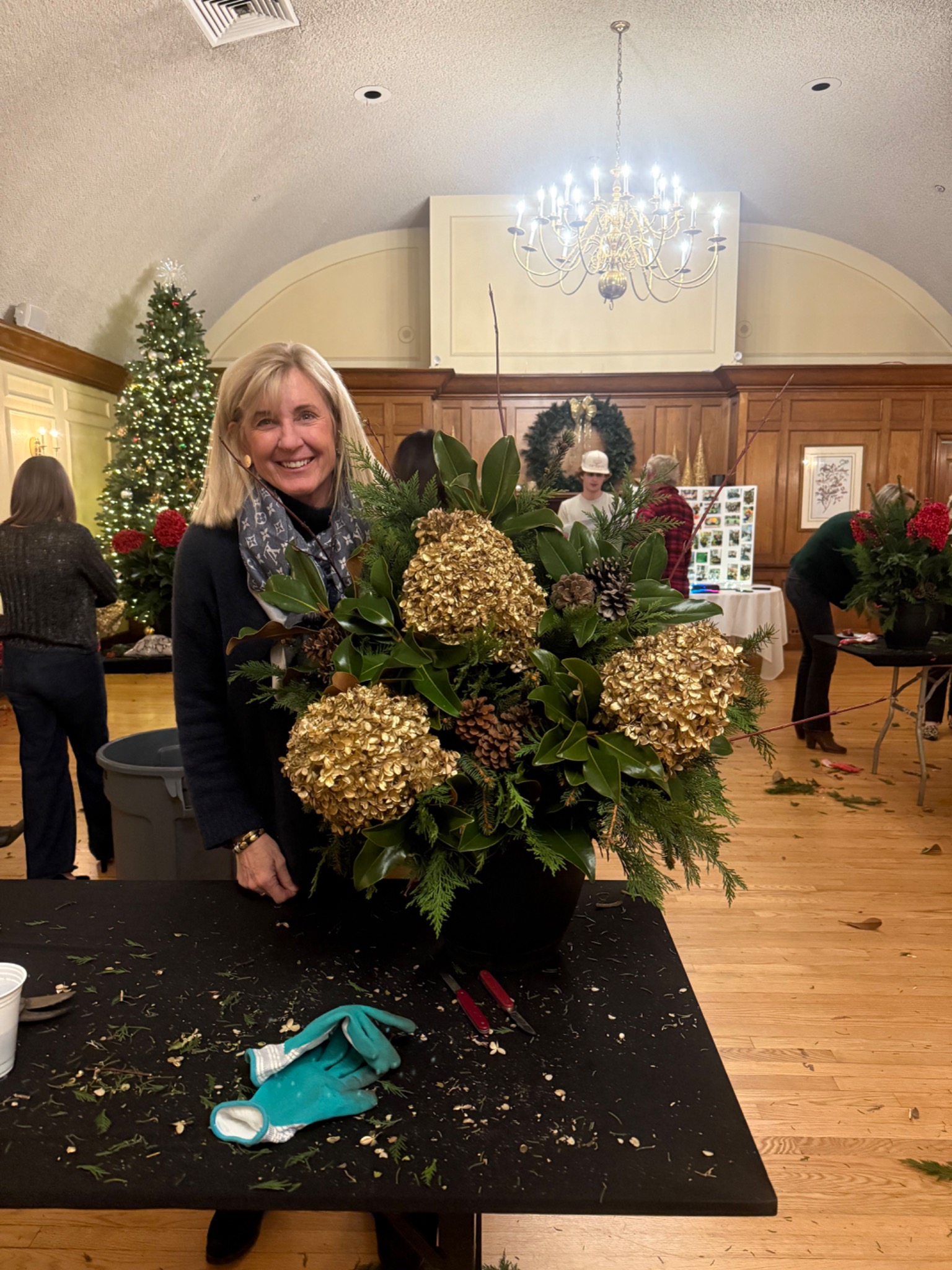 A guest with a golden hydrangea and magnolia arrangement
