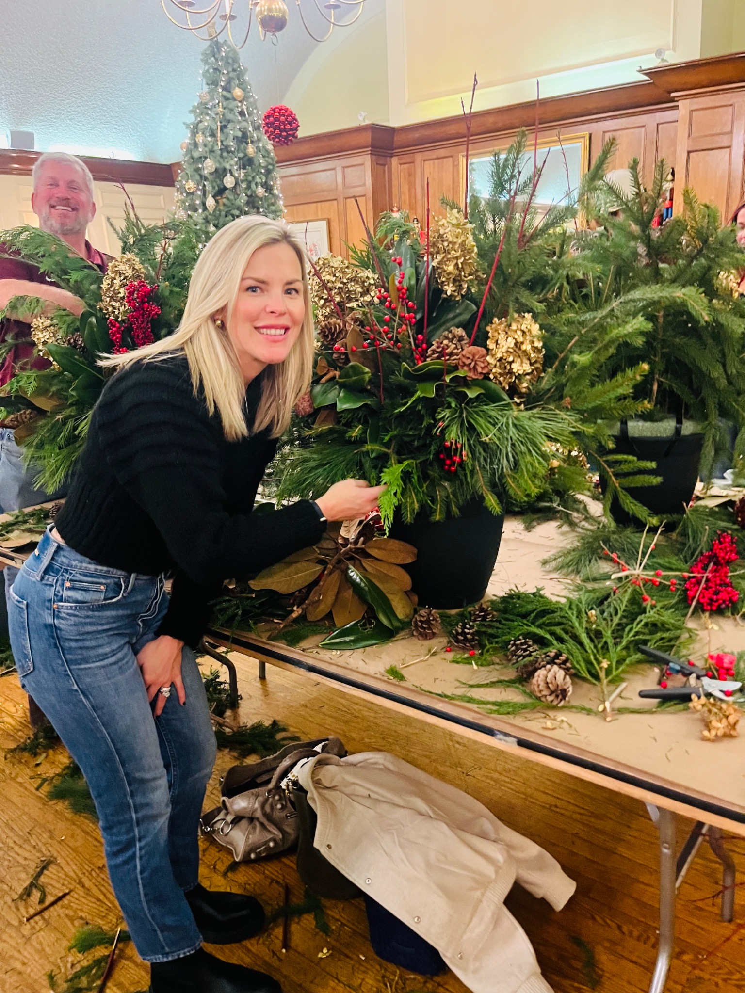A guest arranging fresh greens at the holiday workshop