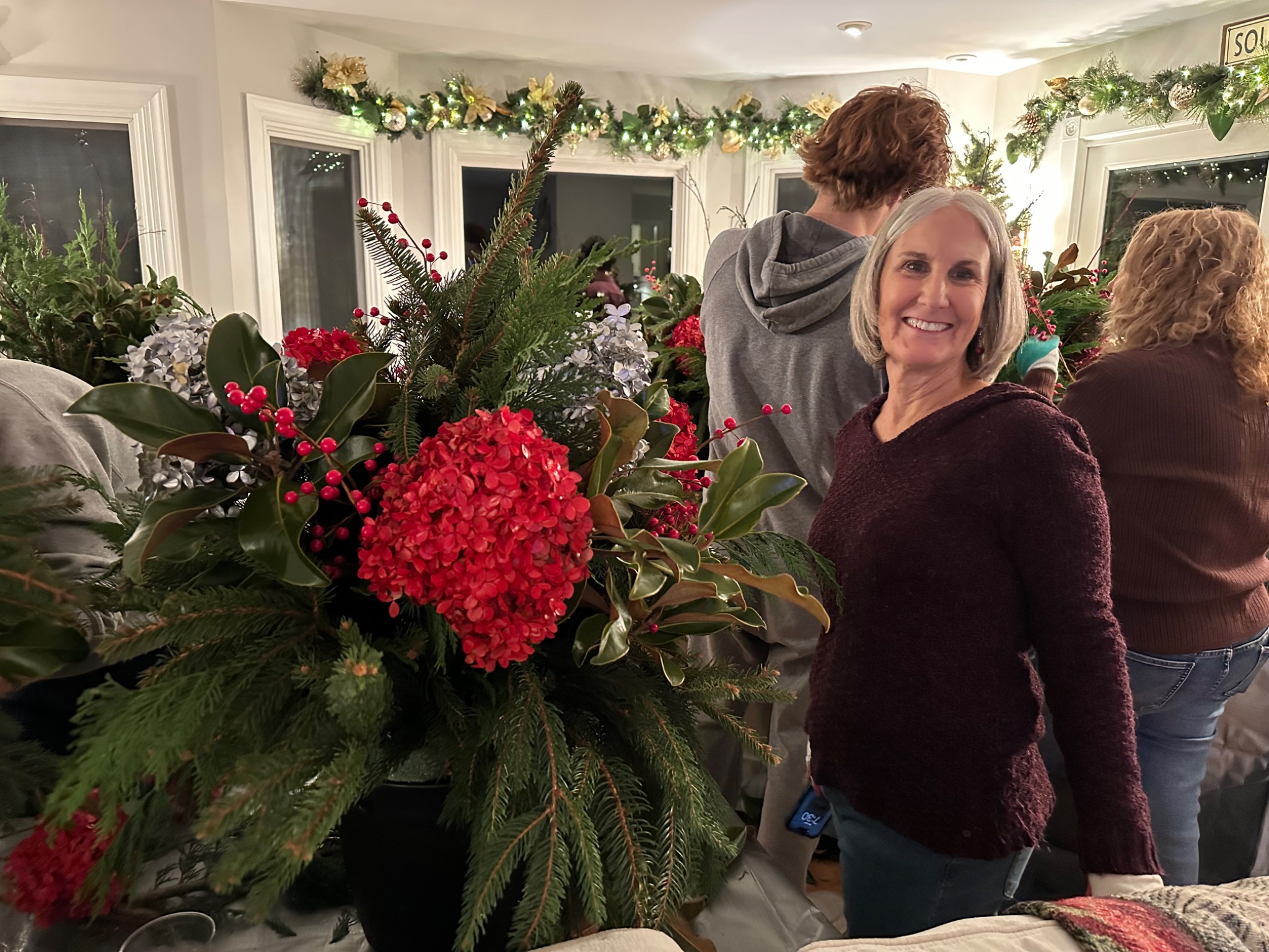 A guest holding a lush red and white holiday arrangement
