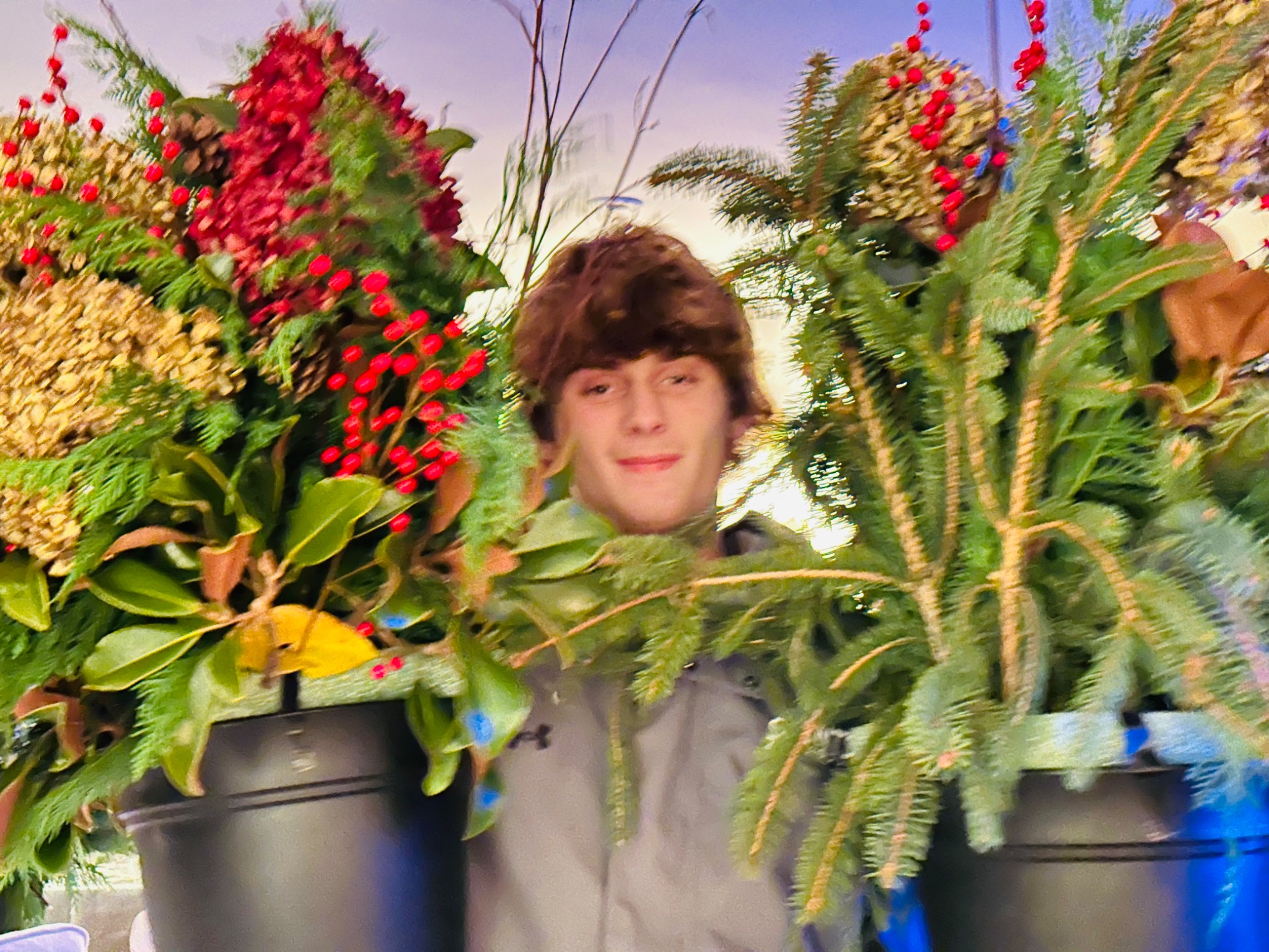 A young guest standing among finished holiday arrangements