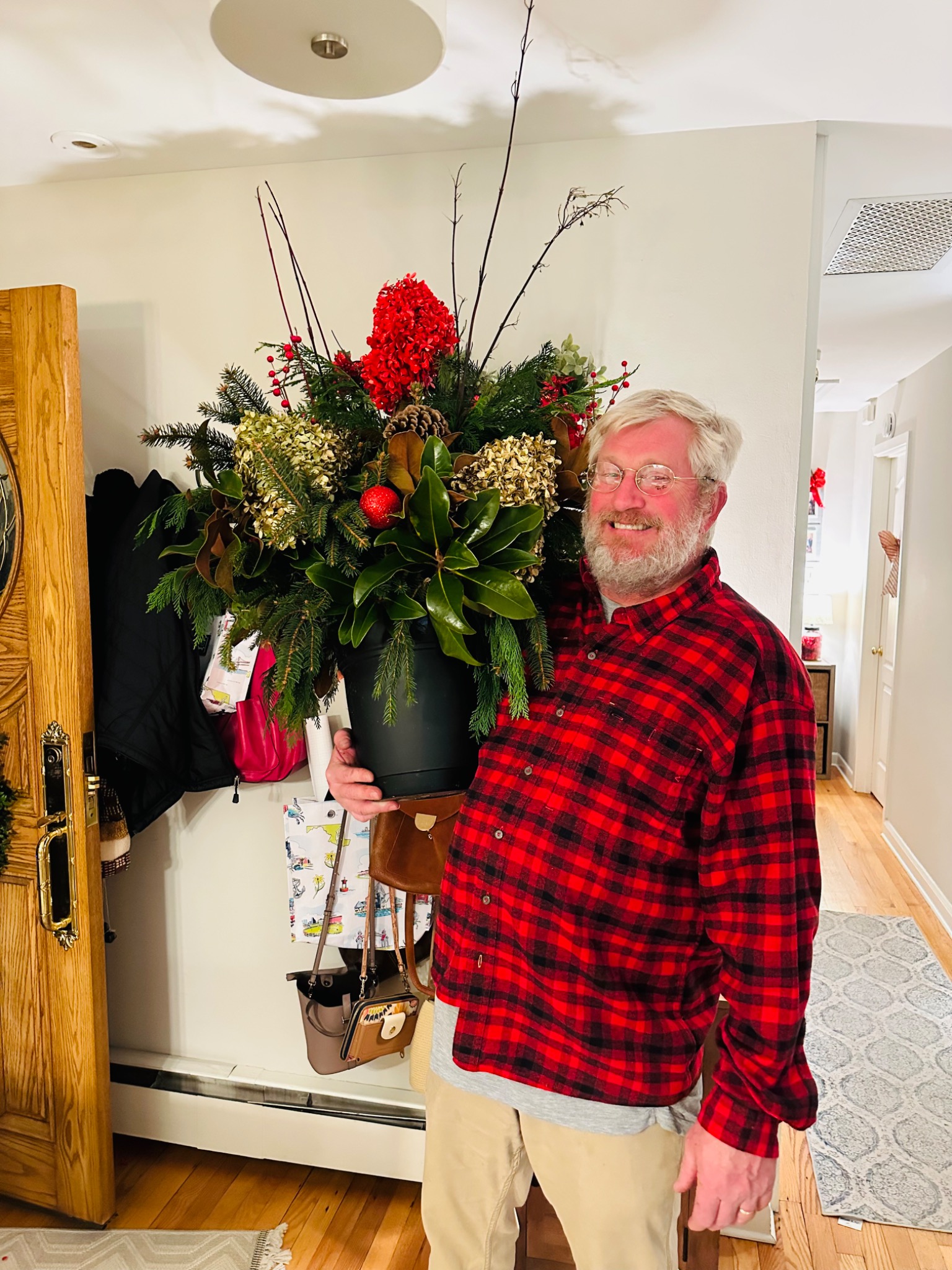 Derek holding a finished evergreen and red berry holiday planter