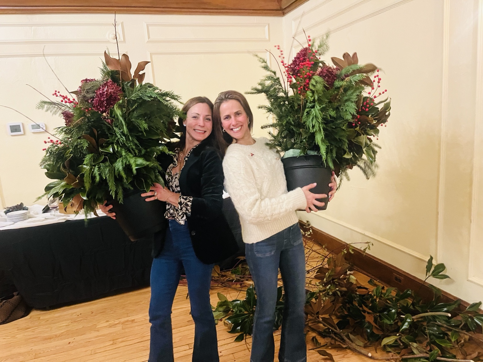 Two guests holding lush finished holiday planters