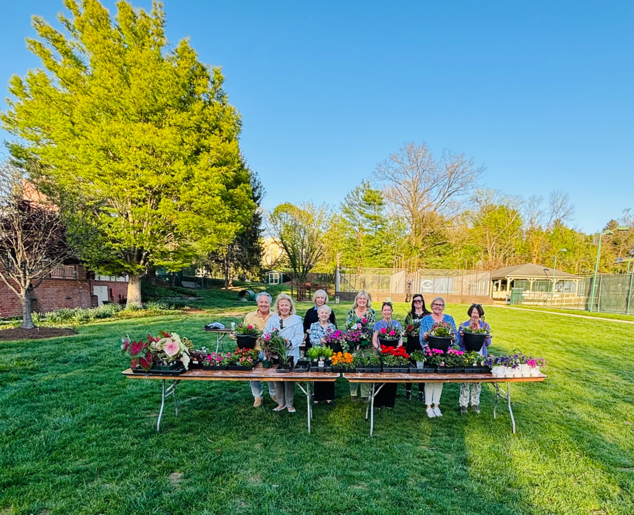 A group of guests with their seasonal planters at an outdoor container workshop