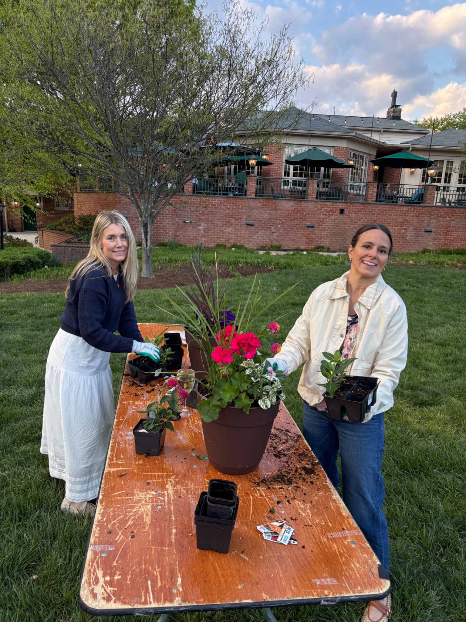 Guests planting colorful seasonal containers together at an outdoor workshop