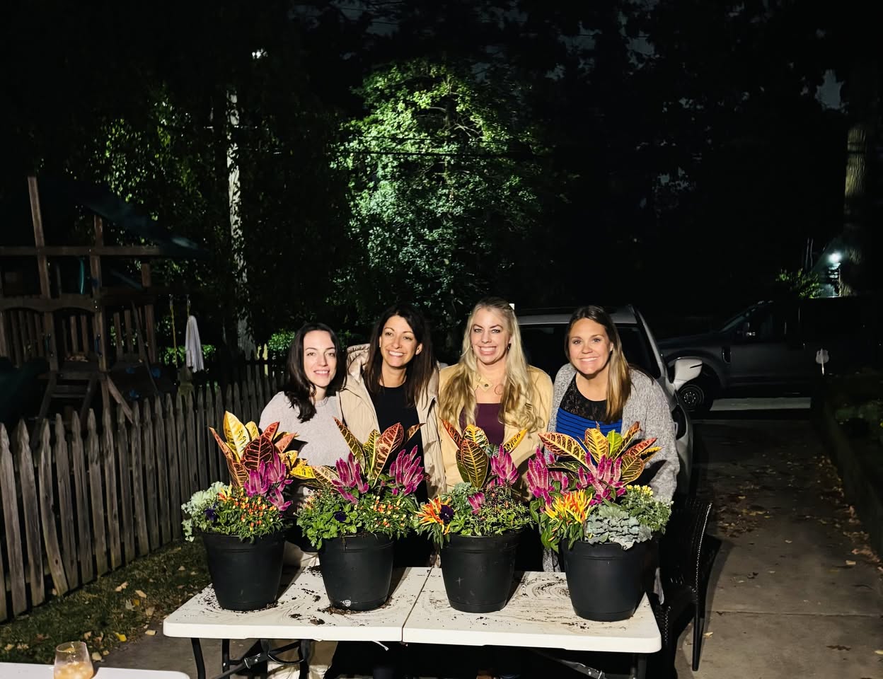 Friends showing their finished seasonal container arrangements